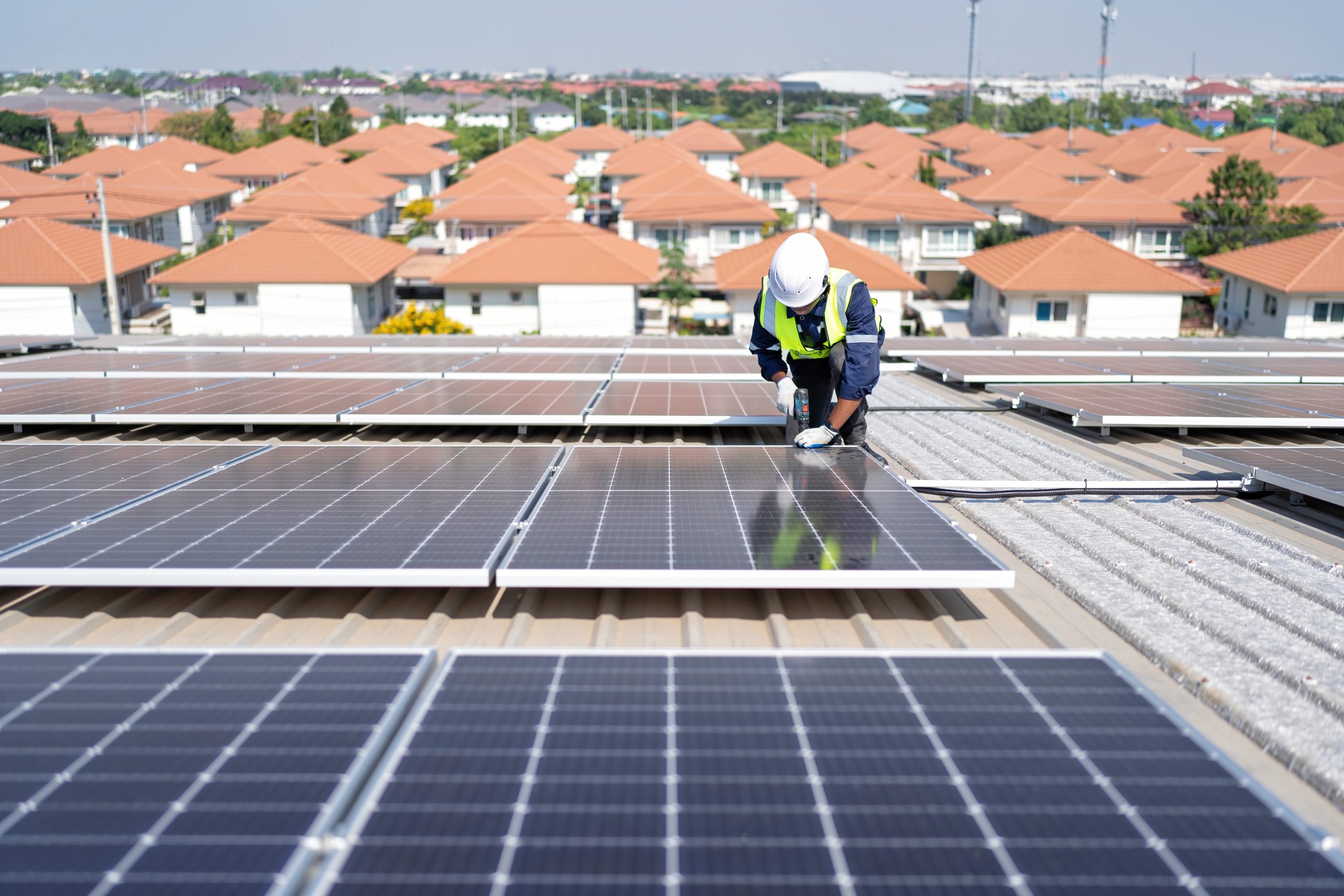 engineer on rooftop kneeling next to solar panels 2024 10 18 07 15 39 utc scaled